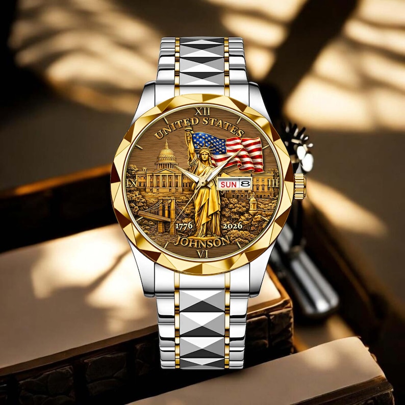 Peut inclure: Montre-bracelet bicolore avec lunette dor&eacute;e et bracelet argent&eacute;. Le cadran repr&eacute;sente la Statue de la Libert&eacute; avec le drapeau am&eacute;ricain, avec les inscriptions "UNITED STATES", "1776", "2026" et "JOHNSON VI".