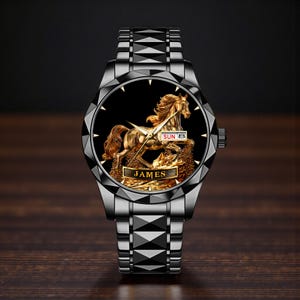 May include: A black and silver wristwatch with a gold horse design on the face. The watch face displays "SUN 8" and the name "JAMES". The watch has a black band and a geometric bezel.
