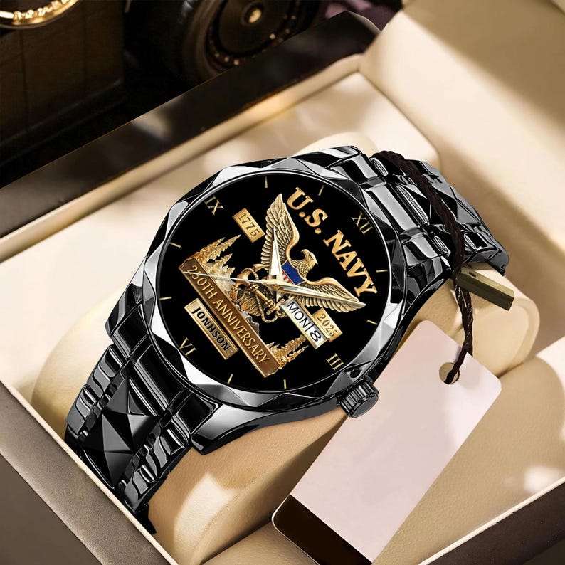 May include: A black wristwatch with a black band. The watch face features the text "U.S. NAVY" and "250th Anniversary" with an eagle emblem. The watch is presented in a gift box.