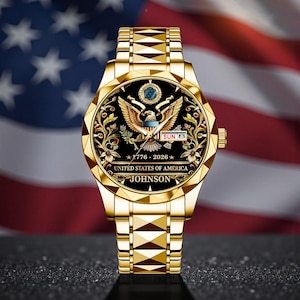 May include: A gold-toned wristwatch with a black face featuring the United States of America's emblem, the date, and the name "JOHNSON." The watch has a gold band and is set against a backdrop of the American flag.