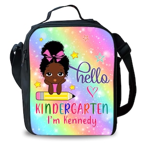 Peut inclure: Un sac &agrave; d&eacute;jeuner noir avec un fond arc-en-ciel et des paillettes. Une fille de dessin anim&eacute; avec un n&oelig;ud rose est assise sur un crayon jaune. Le texte dit "hello kindergarten I'm Kennedy".