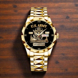 May include: A gold-toned wristwatch with a black face featuring the text "U.S. ARMY", an eagle emblem, and the text "250TH ANNIVERSARY". The watch also displays the date and the name "JONHSON".