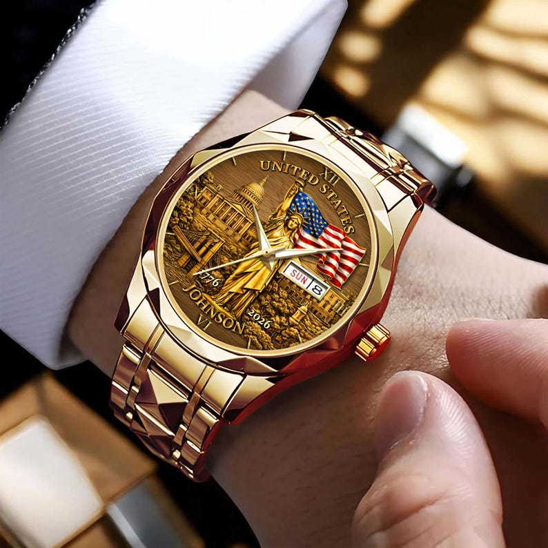 Peut inclure: Montre-bracelet dor&eacute;e avec un cadran d&eacute;taill&eacute; repr&eacute;sentant le Capitole des &Eacute;tats-Unis, la Statue de la Libert&eacute; et un drapeau am&eacute;ricain. Le bracelet et le bo&icirc;tier de la montre sont &eacute;galement dor&eacute;s. Le cadran de la montre comprend le texte "UNITED STATES", "1776", "2026", et "JOHNSON VI".