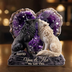 May include: A decorative sculpture featuring two wolves kissing, set against a heart-shaped amethyst crystal. The black and white wolves sit on a rocky base with the text "You & Me We Got This" and names "David" and "Sophia".