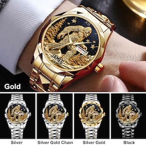 May include: Gold-toned wristwatch with a detailed Sasquatch design on the face. The watch features a gold band and a black and gold face with the word "JAMES" and the day of the week. Additional watch options include silver, silver gold chain, silver gold, and black.