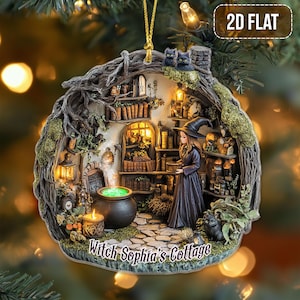 Könnte beinhalten: Detaillierter Weihnachtsschmuck in Form eines Hexenhauses. Der Schmuck zeigt eine Hexe in einem schwarzen Kleid, einen brodelnden Kessel und den Text "Witch Sophia's Cottage". Das Haus ist von Büchern, Kerzen und zwei schwarzen Katzen umgeben.