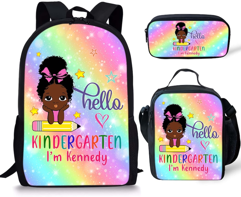 Peut inclure: Un ensemble scolaire trois pi&egrave;ces avec un motif arc-en-ciel et &eacute;toiles. L'ensemble comprend un sac &agrave; dos, une bo&icirc;te &agrave; lunch et une trousse. Le sac &agrave; dos a un grand compartiment zipp&eacute; et des bretelles r&eacute;glables. La bo&icirc;te &agrave; lunch a une fermeture &agrave; glissi&egrave;re et une poign&eacute;e. La trousse a une fermeture &agrave; glissi&egrave;re. Les trois pi&egrave;ces pr&eacute;sentent une fille de dessin anim&eacute; avec un n&oelig;ud rose et le texte "hello kindergarten I'm Kennedy".