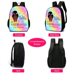 Peut inclure: Un sac &agrave; dos noir avec un motif arc-en-ciel repr&eacute;sentant une fille de dessin anim&eacute; tenant un crayon. Le sac &agrave; dos porte le texte "hello" et "KINDERGARTEN I'm Kennedy".