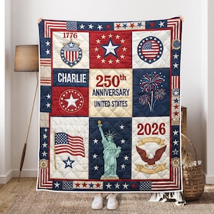 Pu&ograve; includere: Una trapunta patriottica con un design patchwork nei colori rosso, bianco e blu. La trapunta include immagini della bandiera americana, della Statua della Libert&agrave; e di un'aquila, insieme al testo "1776", "Charlie", "250th Anniversary United States" e "2026".