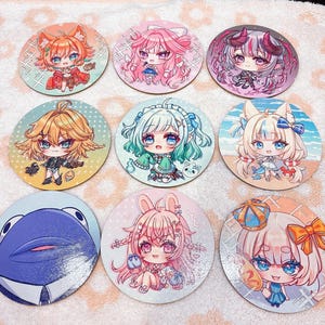 May include: Nine round coasters featuring anime-style illustrations of various characters. Each coaster has a unique design with vibrant colors, including characters with animal ears, horns, and other fantasy elements. The coasters are arranged on a white surface.