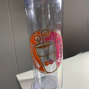K&ouml;nnte beinhalten: Ein durchsichtiger Plastikbecher mit einem pinkfarbenen und orangenen Dunkin' Donuts-Logo. Das Logo zeigt eine stilisierte Kaffeetasse mit aufsteigendem Dampf und dem Text "Dunkin' Donuts".
