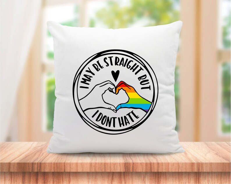 Pu&ograve; includere: Cuscino bianco con una grafica in bianco e nero di due mani che formano un cuore con un arcobaleno al suo interno. Il testo intorno al cuore dice "Potrei essere etero, ma non odio".