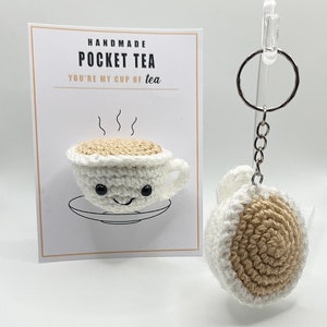 May include: Handmade crocheted teacup keychain with a brown tea-colored center and the text "Handmade Pocket Tea You're my cup of tea".