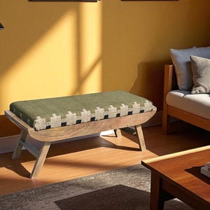 May include: A wooden bench with a green and white patterned cushion. The bench has a curved design and angled legs. The room has a yellow wall, a sofa, a coffee table, and a floor lamp.