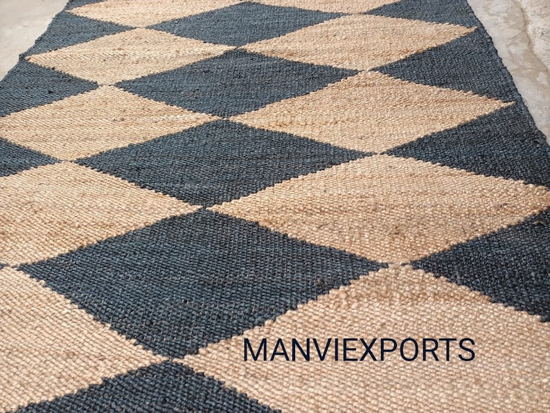 May include: A black and natural jute rug with a diamond pattern. The rug is woven with a textured, natural fiber. The rug is made by MANVIEXPORTS.
