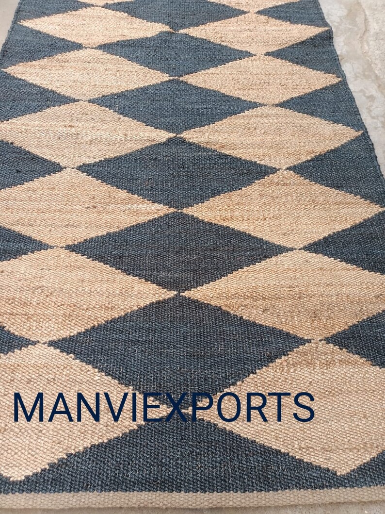 May include: A black and beige jute rug with a diamond pattern. The rug has the text "MANVIEXPORTS" woven into the bottom edge.