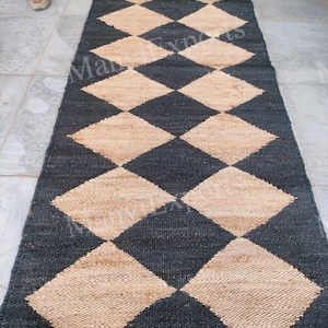 May include: A black and beige checkered jute rug. The rug is made of natural fibers and has a woven texture.