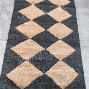 May include: A black and beige checkered rug made of woven jute. The rug has a diamond pattern and is perfect for adding a touch of natural texture to any room.