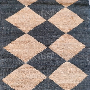May include: A black and beige woven rug with a diamond pattern. The rug is made of natural fibers and has a rustic look.