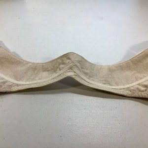 May include: Beige bra with adjustable straps and a hook and eye closure. The bra is made of a soft, comfortable fabric.