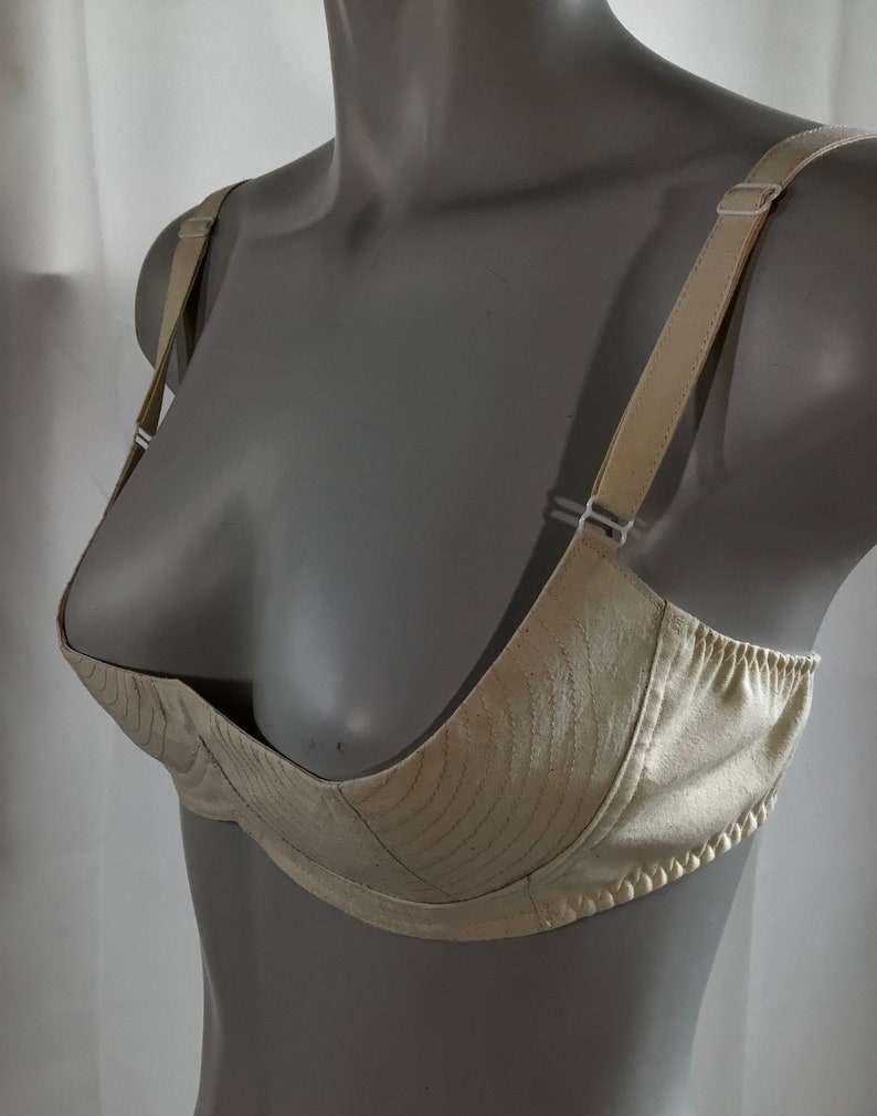 May include: A white satin bra with adjustable straps. The bra has a smooth, seamless design and a low-cut neckline.