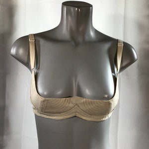 May include: A white, lightly padded bra with adjustable straps. The bra has a simple design with a curved, scalloped neckline.