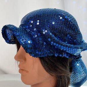 May include: A blue sequined hat with a floppy brim. The hat is made of a soft, stretchy material and is perfect for adding a touch of sparkle to any outfit.
