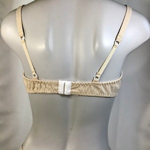 May include: A beige bra with adjustable straps and a hook and eye closure in the back.