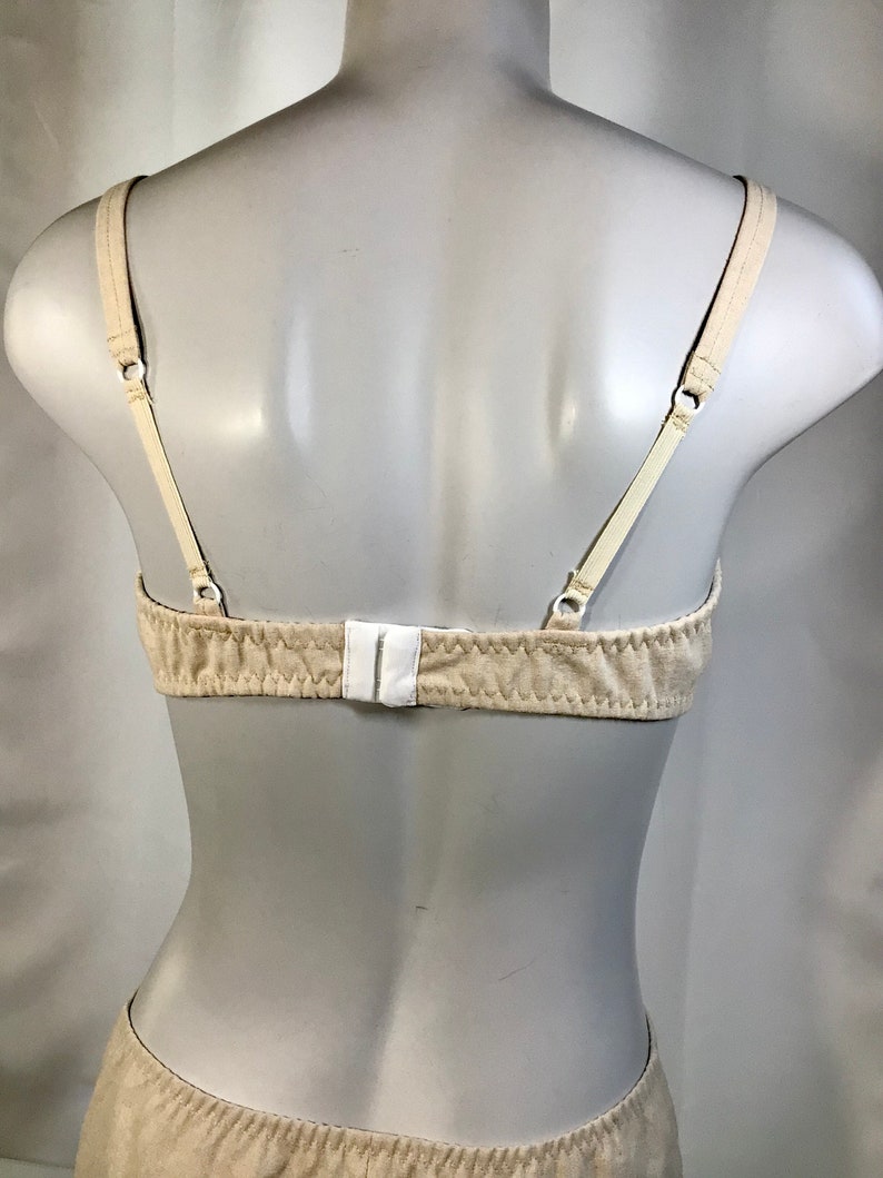 May include: A beige bra with adjustable straps and a hook and eye closure in the back.