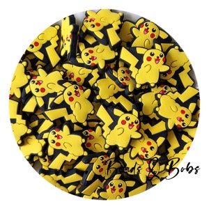 Może przedstawiać: Kolekcja żółto-czarnych zawieszek w kształcie Pikachu. Każda zawieszka ma żółte ciało, czerwone policzki i czarny wzór błyskawicy. Zawieszki są rozrzucone w okrągłym układzie.