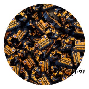 May include: A collection of small, flat, rubberised excavator charms in yellow, black, and grey. Each piece features a detailed construction vehicle design with a cab, tracks, and an articulated arm. The text "Bobs & Bobs" is visible in black script.