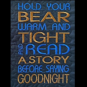 May include: A black quilted fabric with gold and blue embroidery that reads "Hold your bear warm and tight and read a story before saying goodnight".