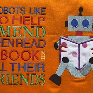 May include: A colorful embroidered design on an orange fabric background features a robot reading a book with the text "Robots like to help and mend then read a book with all their friends".