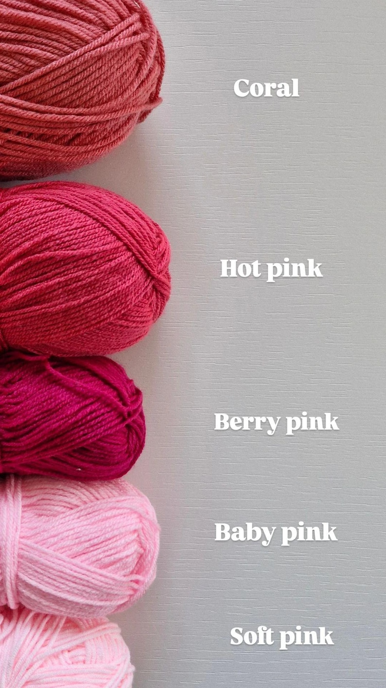 May include: Five skeins of yarn arranged vertically, labelled with white text: Coral, Hot pink, Berry pink, Baby pink, and Soft pink. Each skein features a distinct shade of pink or coral, showcasing a smooth, twisted fibre texture in a stack.