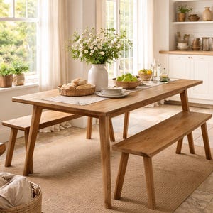 May include: A wooden dining table with two benches, set with plates, flowers, and bread. A woven lampshade hangs above. The room has a neutral colour scheme, with a woven rug. The table is approximately 200 cm long.