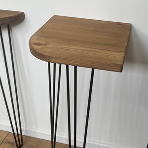 May include: Two wooden tables with black hairpin legs. The tables are made of natural wood and have a rustic look.