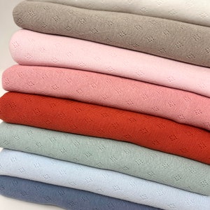 Peut inclure: Un lot de sept &eacute;chantillons de tissu de diff&eacute;rentes couleurs, dont le beige, le rose, le rouge, le vert et le bleu. Le tissu a une texture &agrave; armure ouverte.