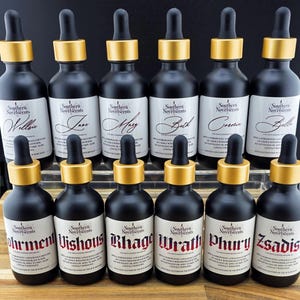 May include: A collection of black glass bottles with gold-coloured tops and droppers. Each bottle features a white label with a unique name in elegant script. The text "Southern Novelscents" is also visible on each label.