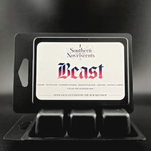 May include: A black wax melt container with three cubes, featuring a label that reads "Southern Novelscents" and "Beast." The label lists scent notes and the text "2.75 OZ (78G) SCENTED WAX." Officially licensed by The JR Ward Shop.