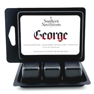 May include: Black wax melt container with three cubes. The label reads "Southern Novelscents George" with scent notes. The container is black and holds 2.75 oz (78g) of scented wax. Officially licensed by The JR Ward Shop.