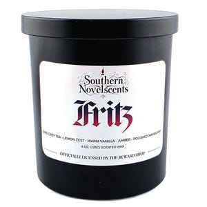 May include: A black scented candle with a white label featuring the text "Southern Novelscents Fritz." The label lists scent notes including Earl Grey Tea, Lemon Zest, and Amber. The candle contains 8 oz (226g) of scented wax.