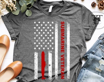 Könnte beinhalten: Dunkelgraues Heather-T-Shirt mit einem weißen, abgenutzten amerikanischen Flaggenmuster und dem Text "SUBMARINE VETERAN" in Rot.