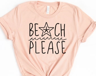 May include: A peach-colored t-shirt with a black graphic that says "BEACH PLEASE" with a star and wavy lines.