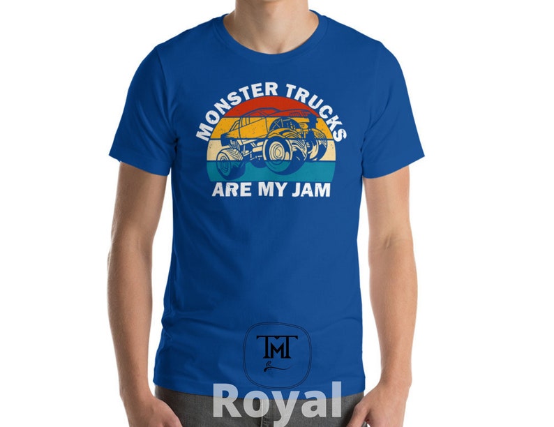 May include: A royal blue t-shirt with a vintage-style graphic of a monster truck. The graphic features a yellow monster truck with red, orange, and blue accents. The text "Monster Trucks Are My Jam" is printed in white on the shirt.