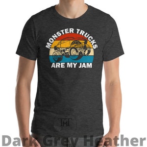 May include: Dark grey heather t-shirt with a vintage-style graphic of a monster truck. The graphic says "Monster Trucks Are My Jam".