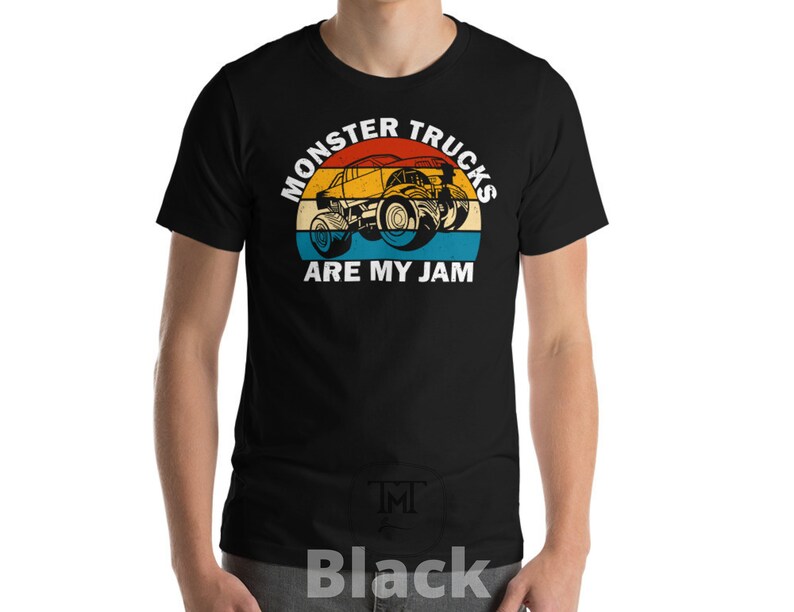May include: Black t-shirt with a vintage-style graphic of a monster truck. The graphic features a red, orange, yellow, and blue color scheme and the text "Monster Trucks Are My Jam".