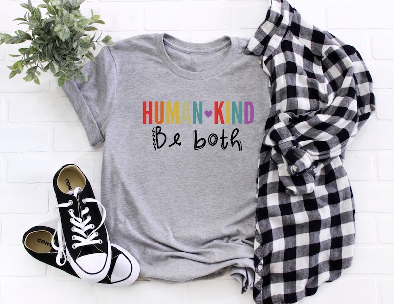 Puede incluir: Camiseta gris con el texto "HUMAN-KIND Be both" en colores arco&iacute;ris con un coraz&oacute;n entre las palabras.