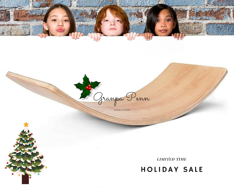 Puede incluir: Una tabla oscilante de madera de color claro con un dise&ntilde;o curvo. El texto "Granpa Penn Wobble Board" es visible. Tambi&eacute;n hay un &aacute;rbol de Navidad y una ramita de acebo. La imagen incluye a tres ni&ntilde;os asom&aacute;ndose por encima de una superficie blanca.