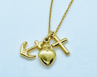May include: A gold necklace featuring a heart, cross, and anchor charm. The charms are all attached to a fine gold chain.
