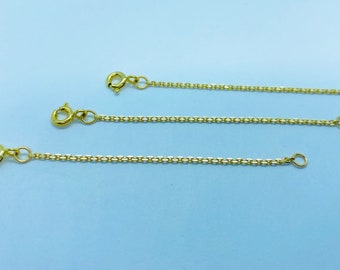 May include: Three gold chain extenders with lobster claw clasps. The extenders are different lengths.